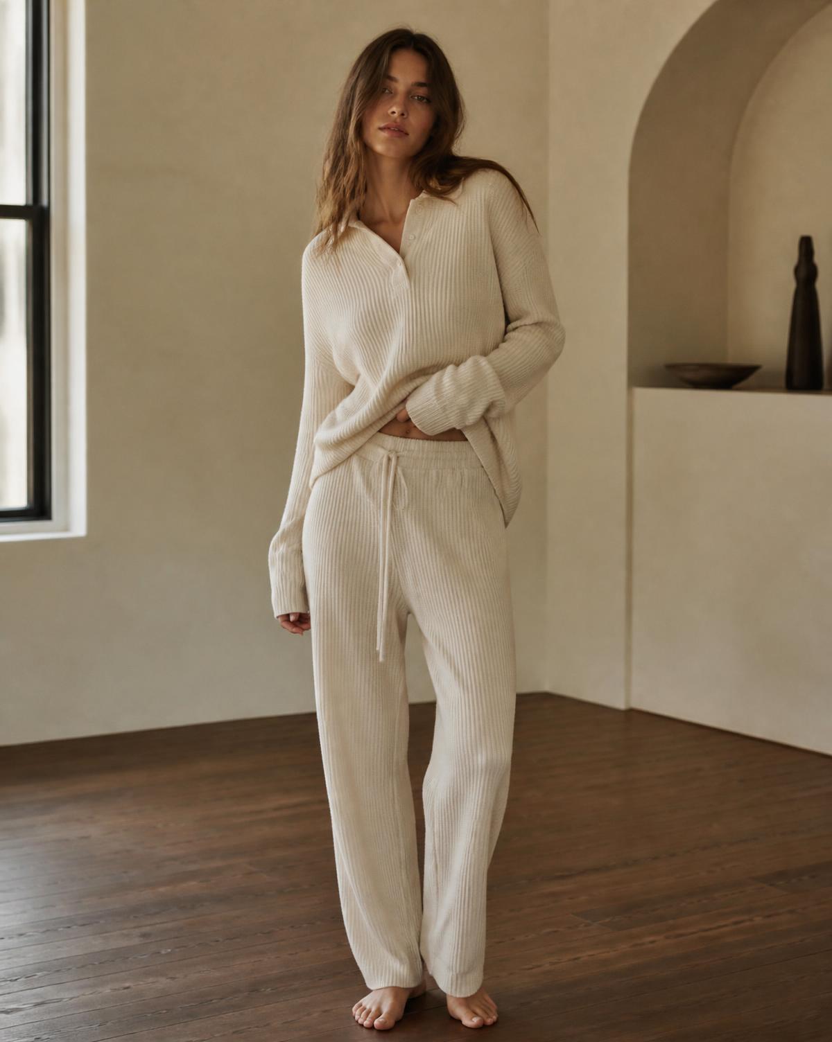 Person wearing a relaxed fit cream Solo Body lounge set at home